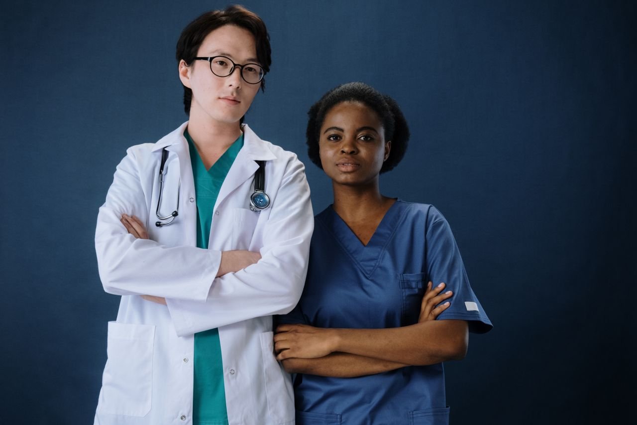 contact-img A confident doctor and nurse posing in a studio setting.
